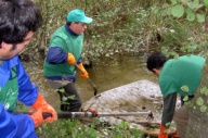 Voluntarios retirando un colch&oacute;n dun r&iacute;o