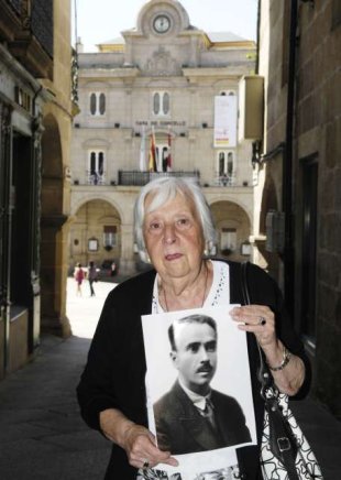 A filla de Manuel Su&aacute;rez sost&eacute;n un retrato de seu pai
