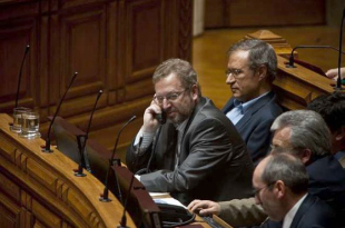 Fazenda, co tel&eacute;fono, nunha sesi&oacute;n da Assembleia da Rep&uacute;blica. &Aacute; s&uacute;a dereita, Francisco Lou&ccedil;&atilde;, candidato do BE nas elecci&oacute;ns do domingo