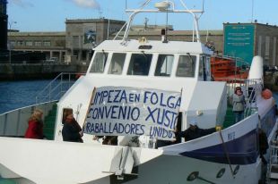 Os manifestantes decidiron desprazarse a Cangas para continuar coas mobilizaci&oacute;ns / Na imaxe, colocando a pancarta na proa