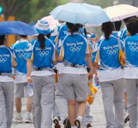 Mozas da organizaci&oacute;n das Olimp&iacute;adas baixo a choiva