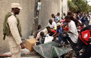 Un grupo de persoas tenta atopar algo de comida entre as ruínas de Porto Príncipe