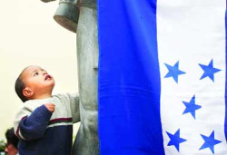 Un neno ante a bandeira de Honduras, nun acto de simpatizantes de Zelaya