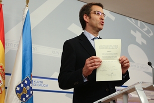 Núñez Feijoo mostra o documento asinado polo presidente de Caixanova e o director xeral de Caixa Galicia