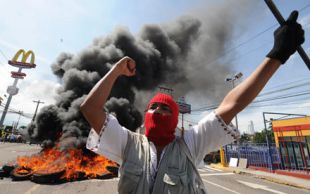 Durante as protestas contra o golpe de Estado, un partidario de Zelaya, coa face tapada