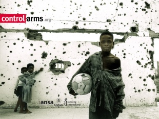 Imaxa da campaña 'Armas baixo control', cuns nenos a xogar contra un muro furado polas balas