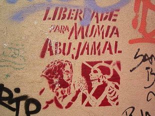 Pintadas que piden a liberdade de Mumia, en Berlín e en Lisboa (a primeira do Flickr de dubnars , e a segunda no de arteurbana)